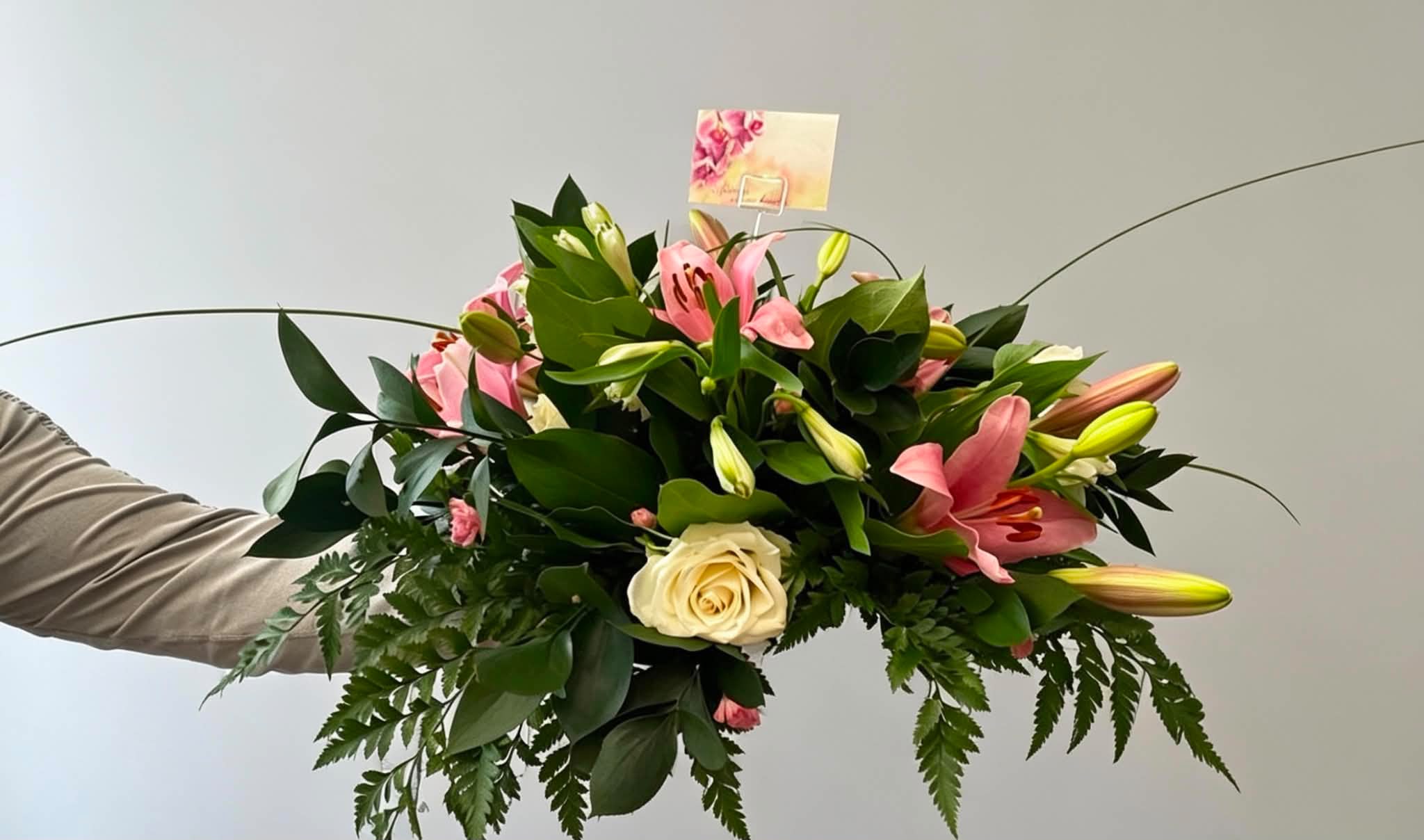 Pink lily and rose funeral arrangement