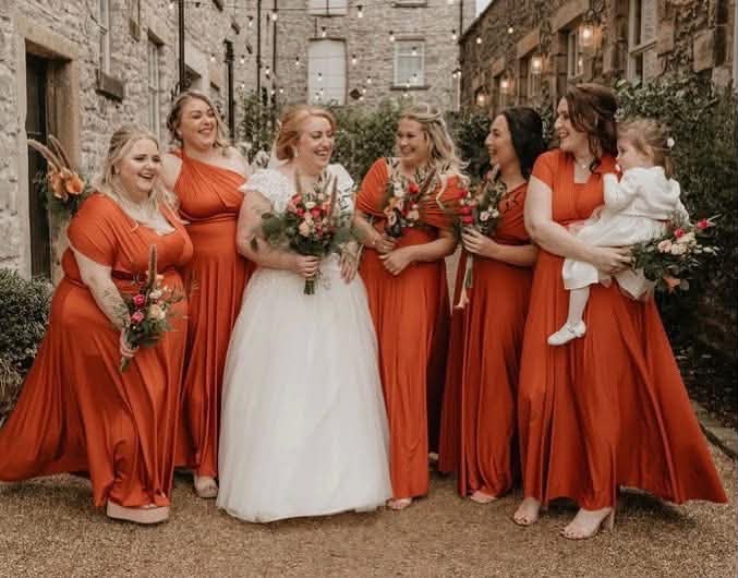 Bride and bridesmaids holding colourful hand-tied bouquets