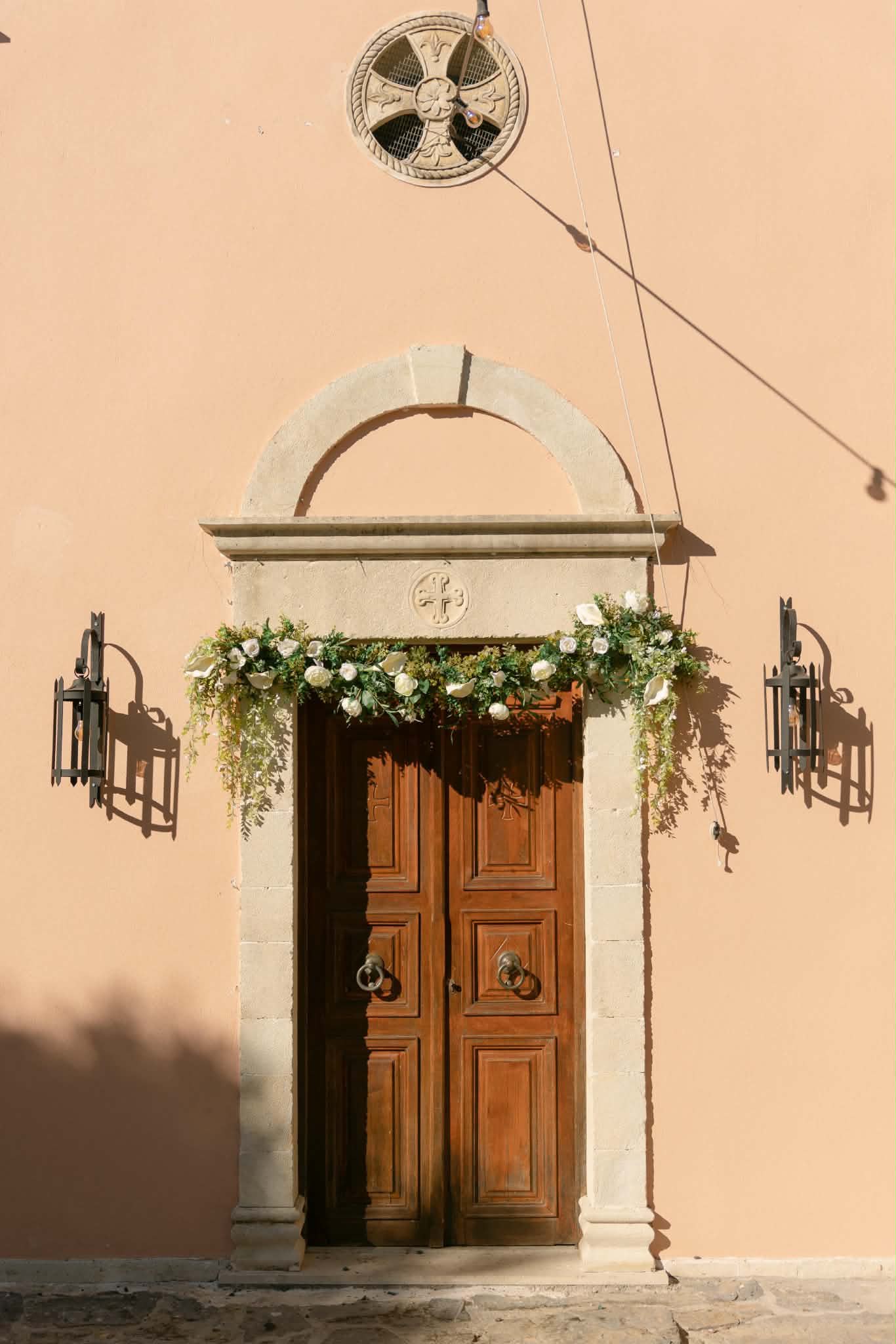 Wedding venue entrance dressed with white flowers and trailing greenery